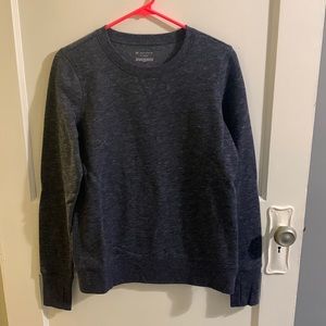 Heathered blue crew neck sweatshirt with thumb loops.